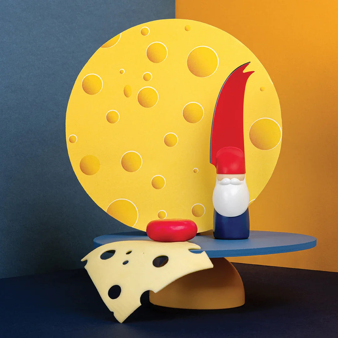 Cheese-themed setup: moon backdrop, Bert cheese knife holder, cheese slices, and a wax cheese wheel.