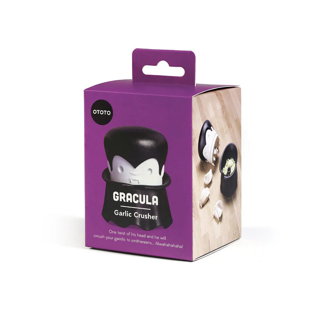 The Gracula crusher by OTOTO has a vampire motif, packaged with cloves on a wooden background.