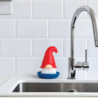 OTOTOs Beardy dish brush adds fun to kitchen chores by the sink with a white tiled backsplash.