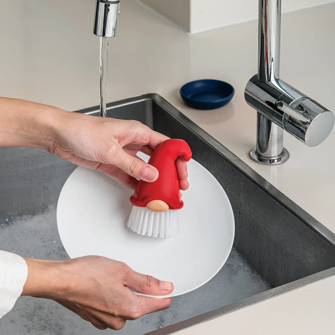 Using Beardy, a gnome dish brush, to wash a plate under running water makes kitchen chores fun with OTOTO.
