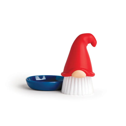 Beardy dish brush with red hat stands ready next to a small blue dish.