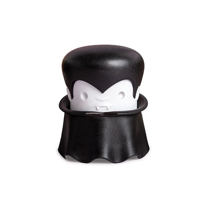 A cartoon vampire with a cape and fangs holds an OTOTO Gracula garlic crusher.