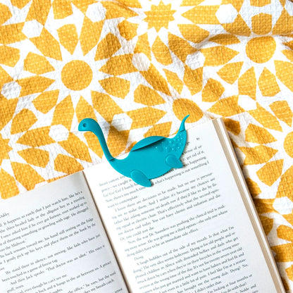 Open your book with Nessie Tale on a yellow and white floral-patterned surface.