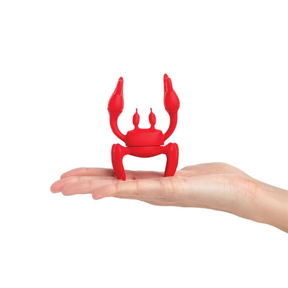 The OTOTO phone holder, Red, mimics a crab on a hand against a white backdrop.