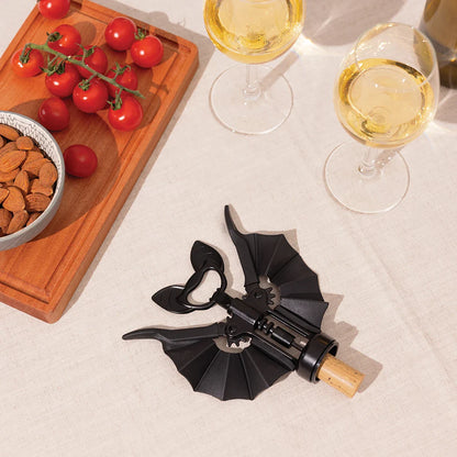 The OTOTO Vino rests beside almonds, cherry tomatoes, and two glasses of white wine.