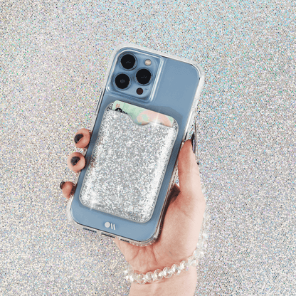 Hand holding phone with Sparkle MagSafe card holder on it. color::Sparkle